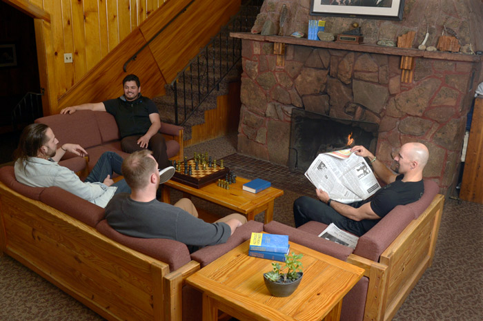 A group sitting on couches by a fireplace at Harmony Recovery, our residential addiction treatment in CO