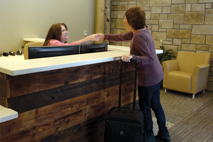 Woman being greeted inside lobby of Harmony Recovery, our addiction evaluation services near Denver